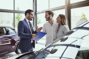 vendedor asesorando clientes en concesionario de autos